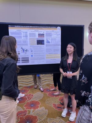 woman standing in front of poster speaking