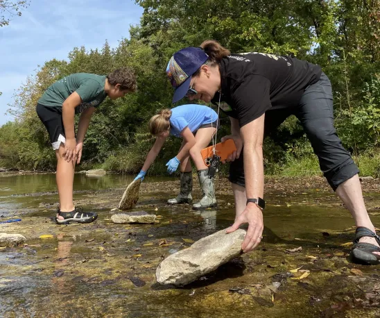Dr Heidi Carlone teaches students (2) Woman and two middle school students standing in a creek
