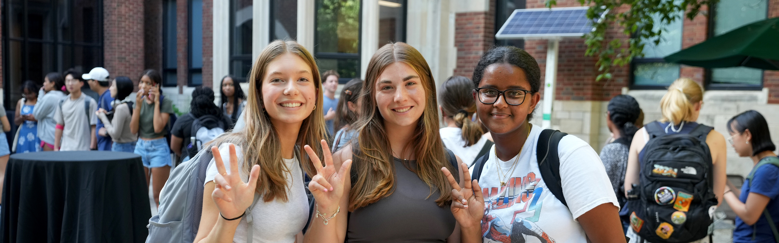Three students holding VU hand sign