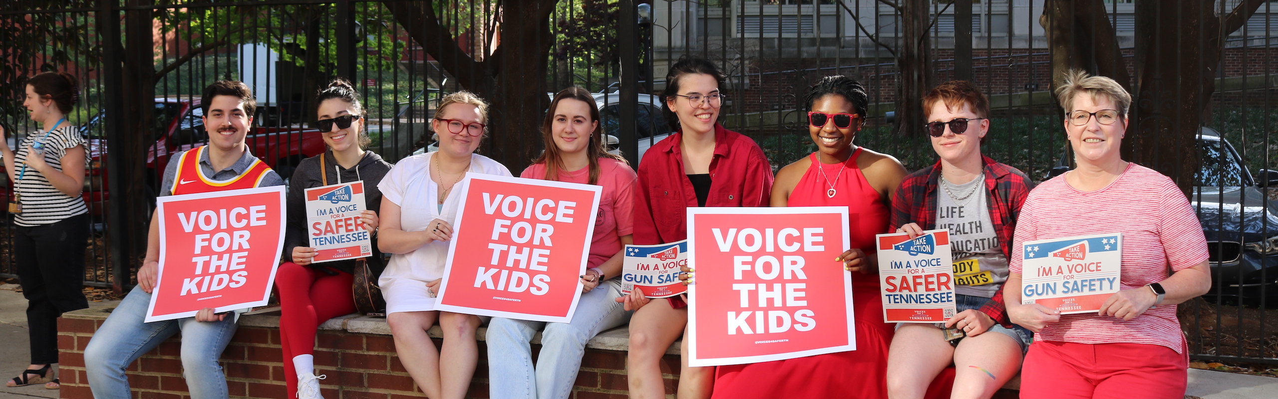 Group sits on ledge holding 