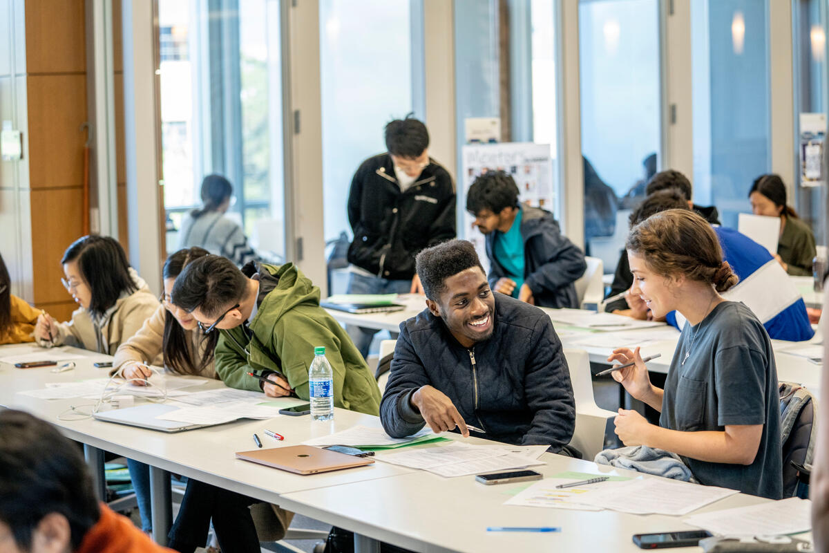 students work on resumes and interact with each other at long tables