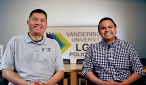 Two men seated and smiling