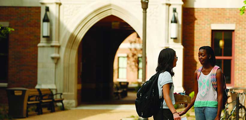 A photo of 2 students chatting outside A photo of 2 students chatting outside