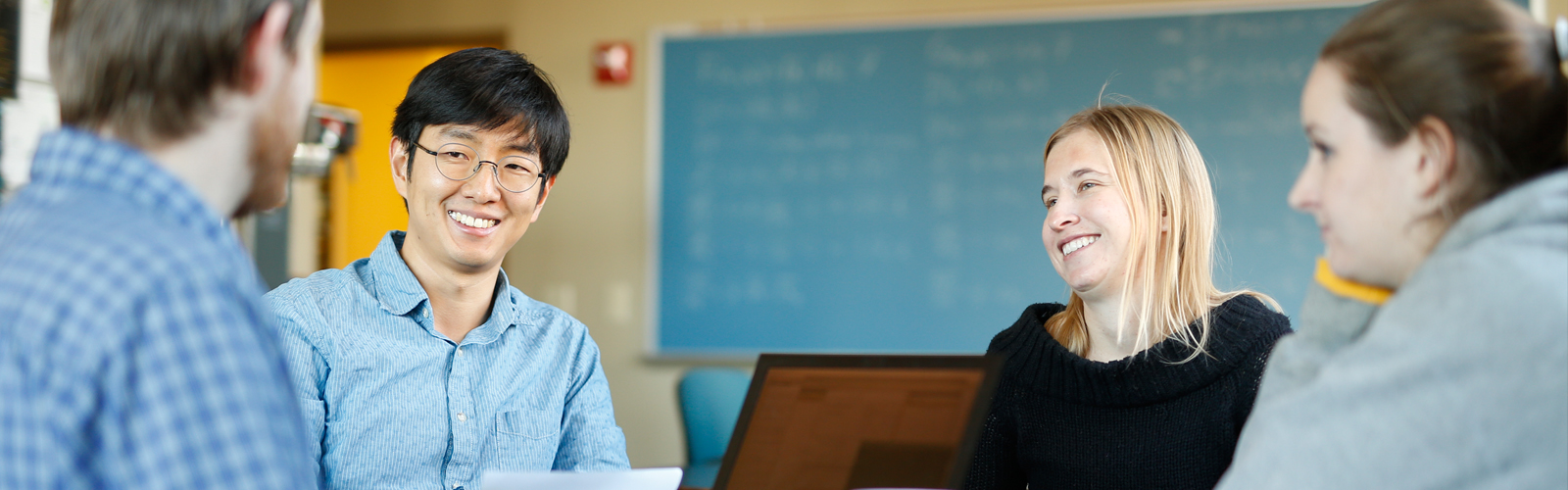 Graduate students talking with professor.