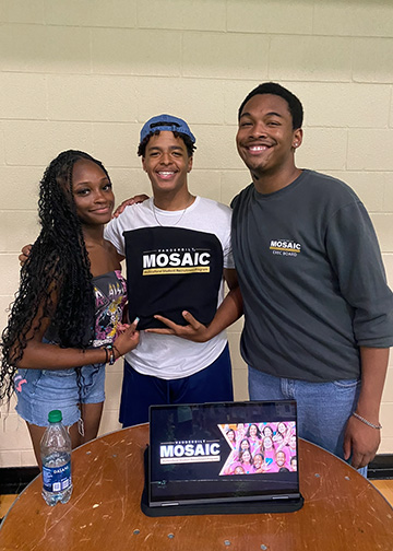 MOSAIC students on Alumni Lawn posing with MOSAIC sign