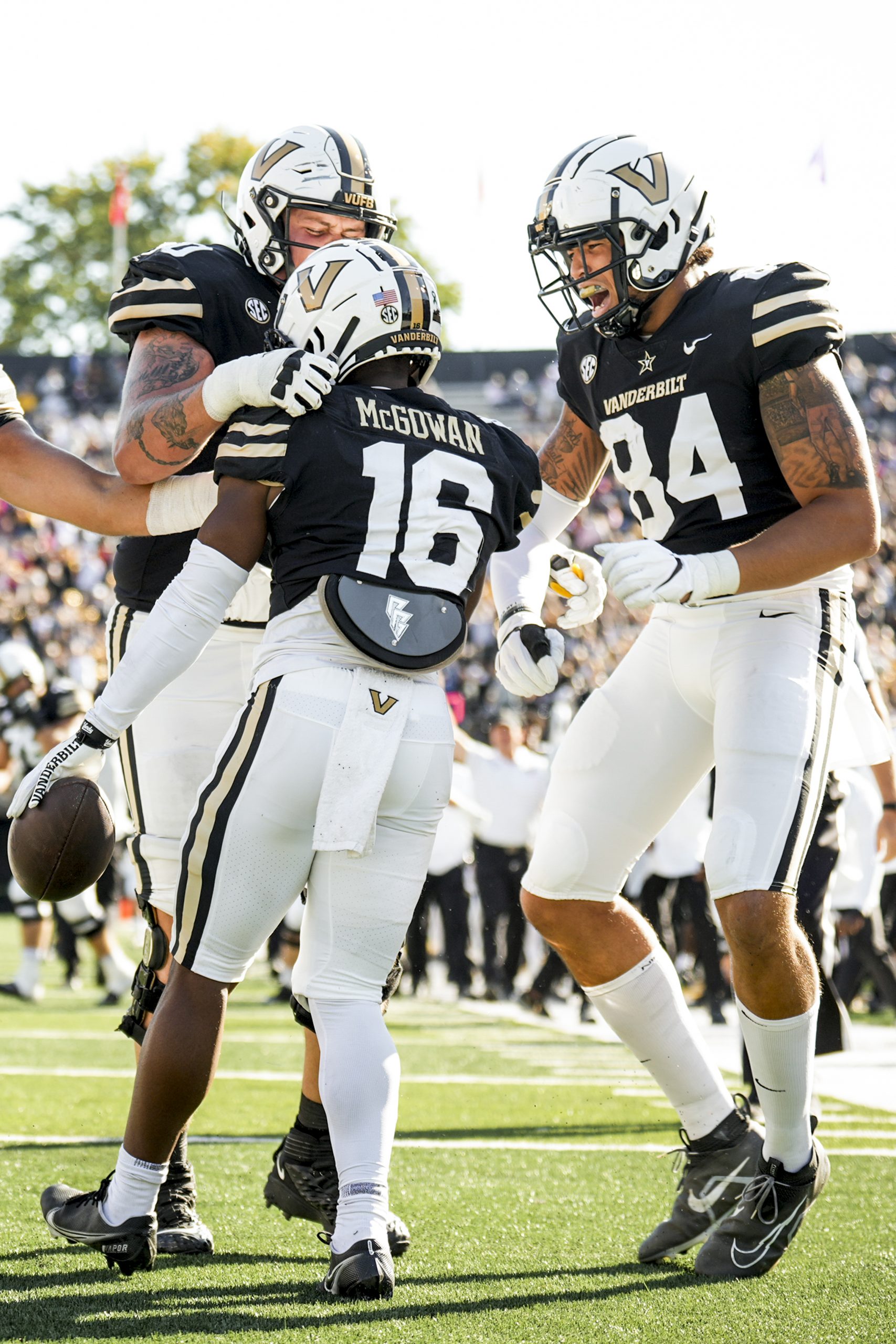 three Vanderbilt football players celebrate after a touchdown