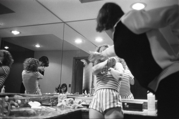 Man striking woman in front of mirror