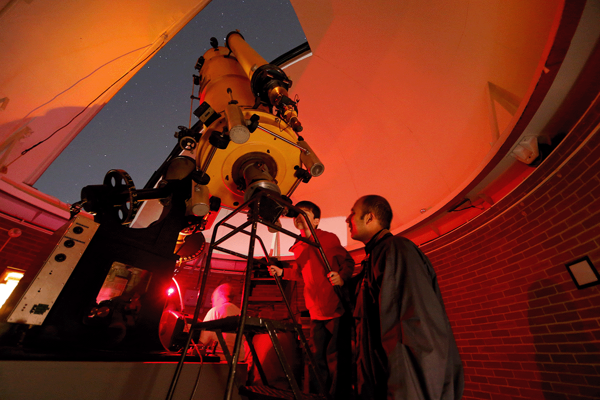 A child and an adult at Vanderbilt Dyer Observatory viewing through the large Seyfert telescope