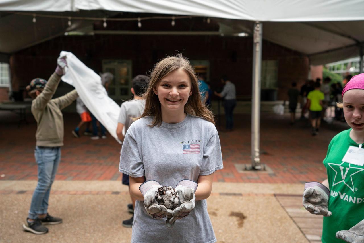 Female child holding her science experiment with gloves at the Dyer Summer Program