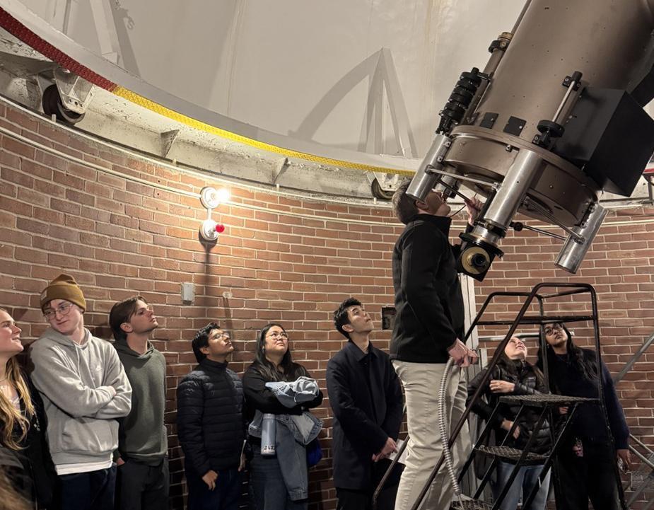 Students wait in line to climb a ladder to see through a telescope