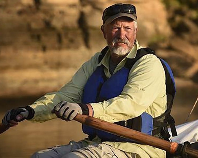 image of John Guider rowing in a boat with oars