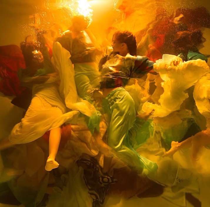Artwork by Christy Lee Rogers, a surreal underwater scene with flowing fabrics and elegantly posed figures in vibrant, golden light, evoking a dreamlike, ethereal atmosphere