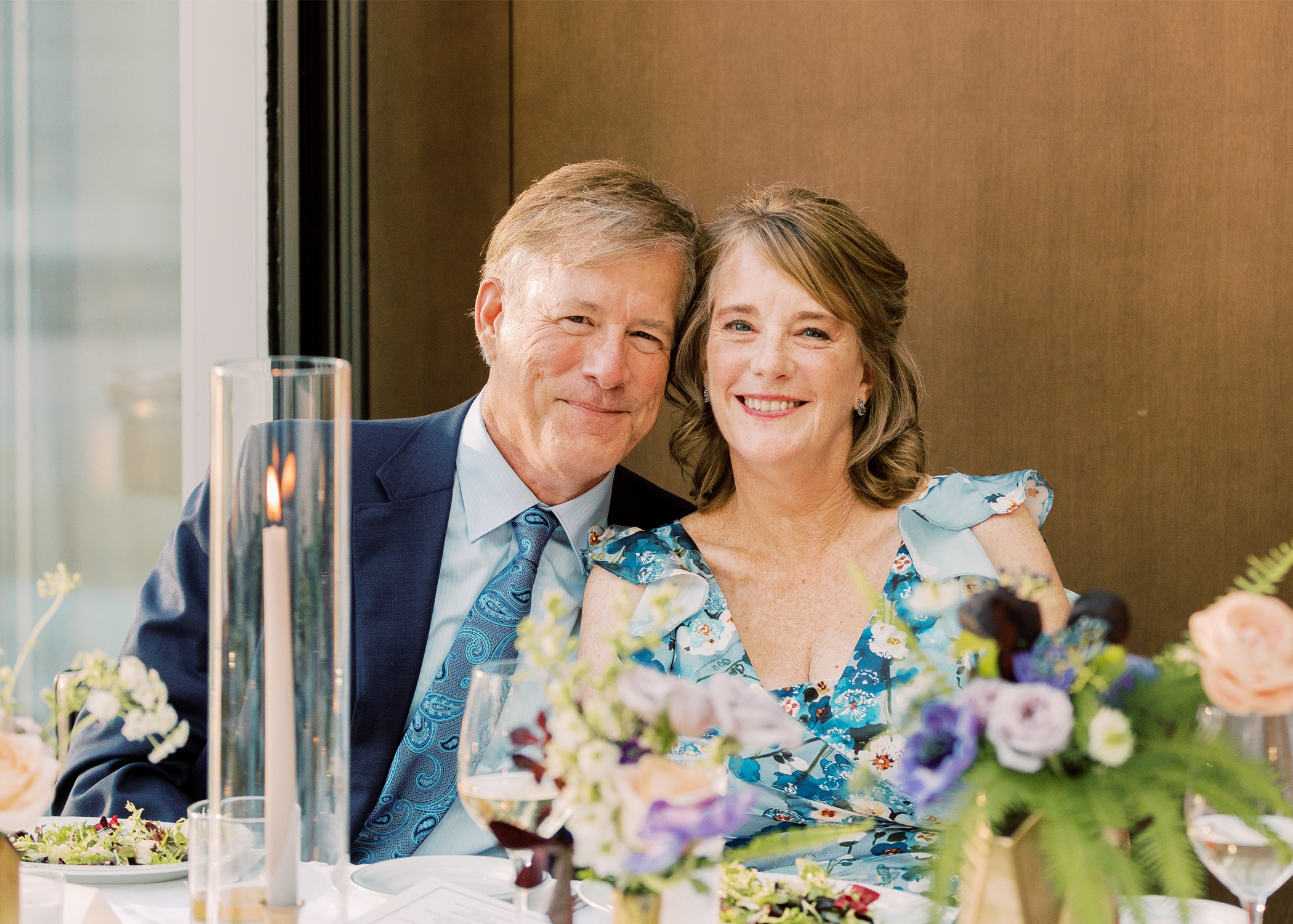 Ed and Lise Spacapan pose for a photo seated together at a dinner table.