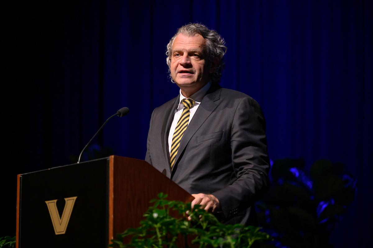 A man standing before a podium in an auditorium