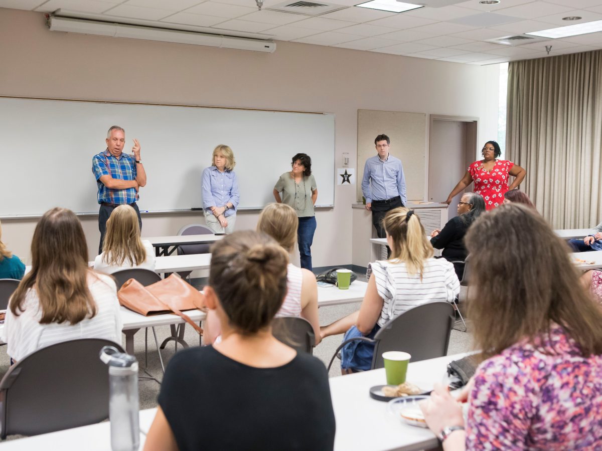 Image Description: Faculty discuss new IRB framework in classroom.