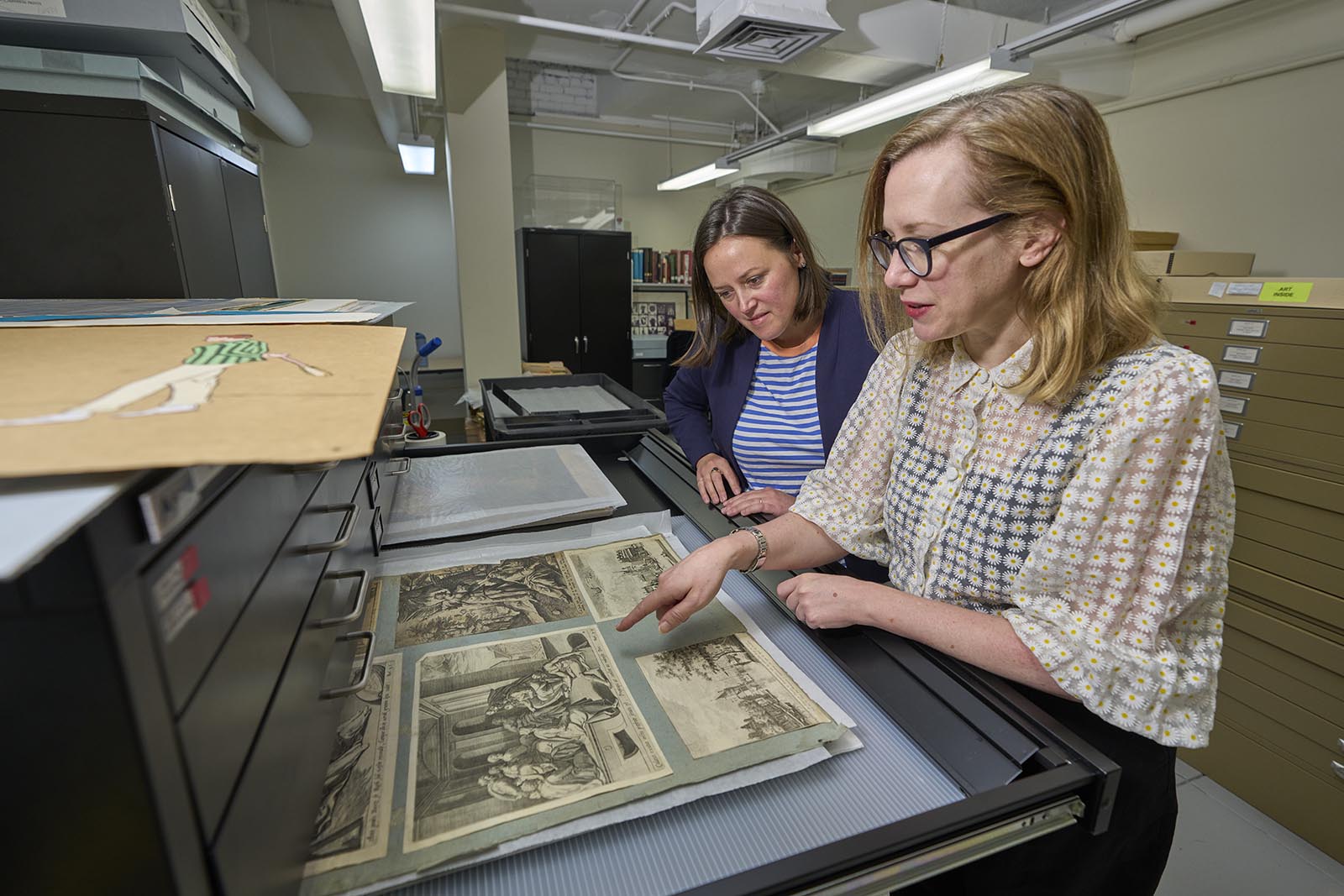 Amanda Hellman, left, director of the Vanderbilt University Museum of Art, and Courtney Wilder, Sullivan Collection curator, look at recent additions to the Sullivan Collection showing how George H. Sullivan kept some prints affixed to album pages. 