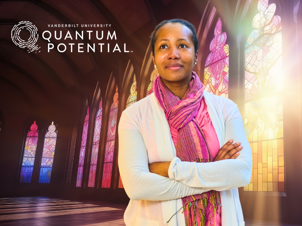 Audrey Bowden stands with her arms crossed in front of stained glass windows. 