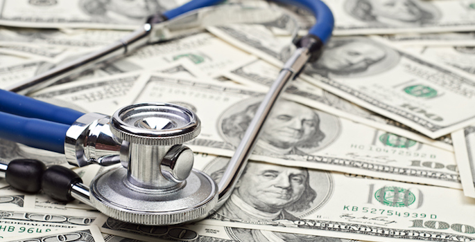 stethoscope resting on a pile of $100 bills