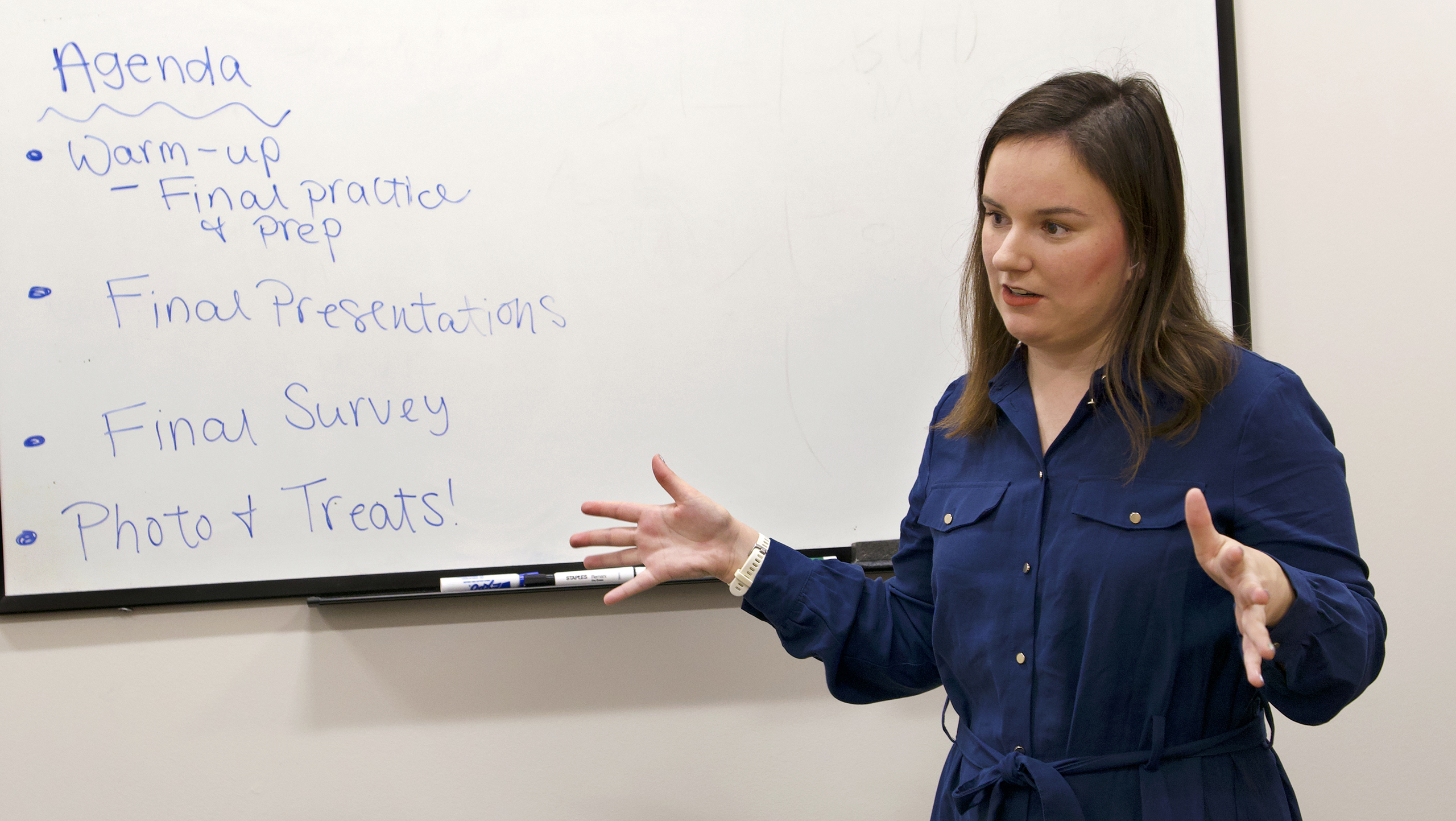 an instructor speaks in front of a white board