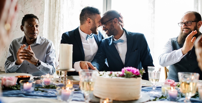 Interracial gay couple celebrates wedding with loved ones