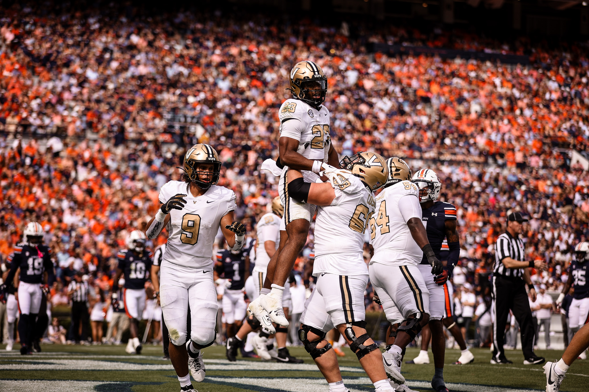 Football players on a field hoisting each other up