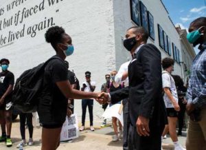 Organizer Grace Jackson shakes hands with Reed