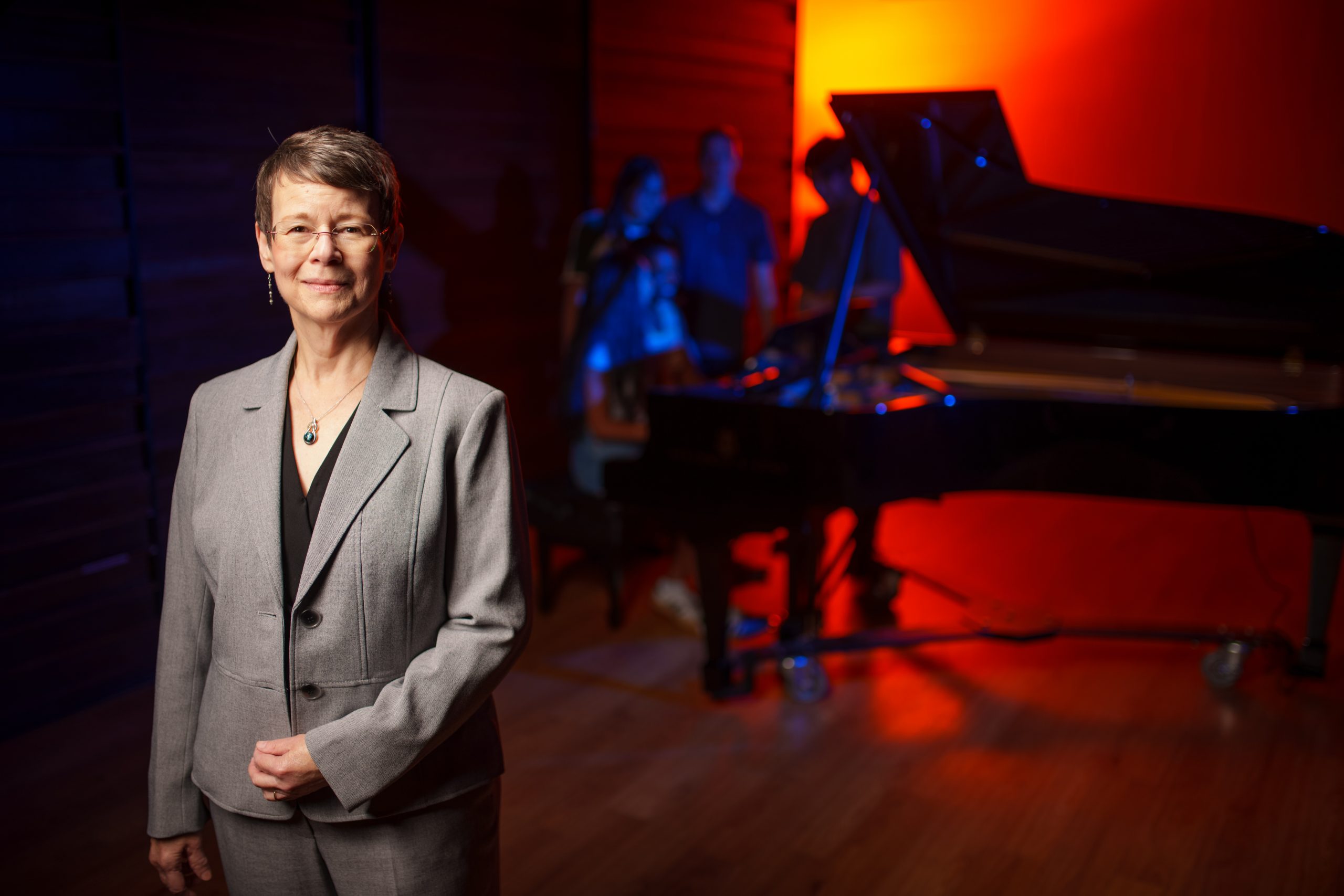 Blair School of Music Dean Melissa Rose stands in front of a grand piano. 