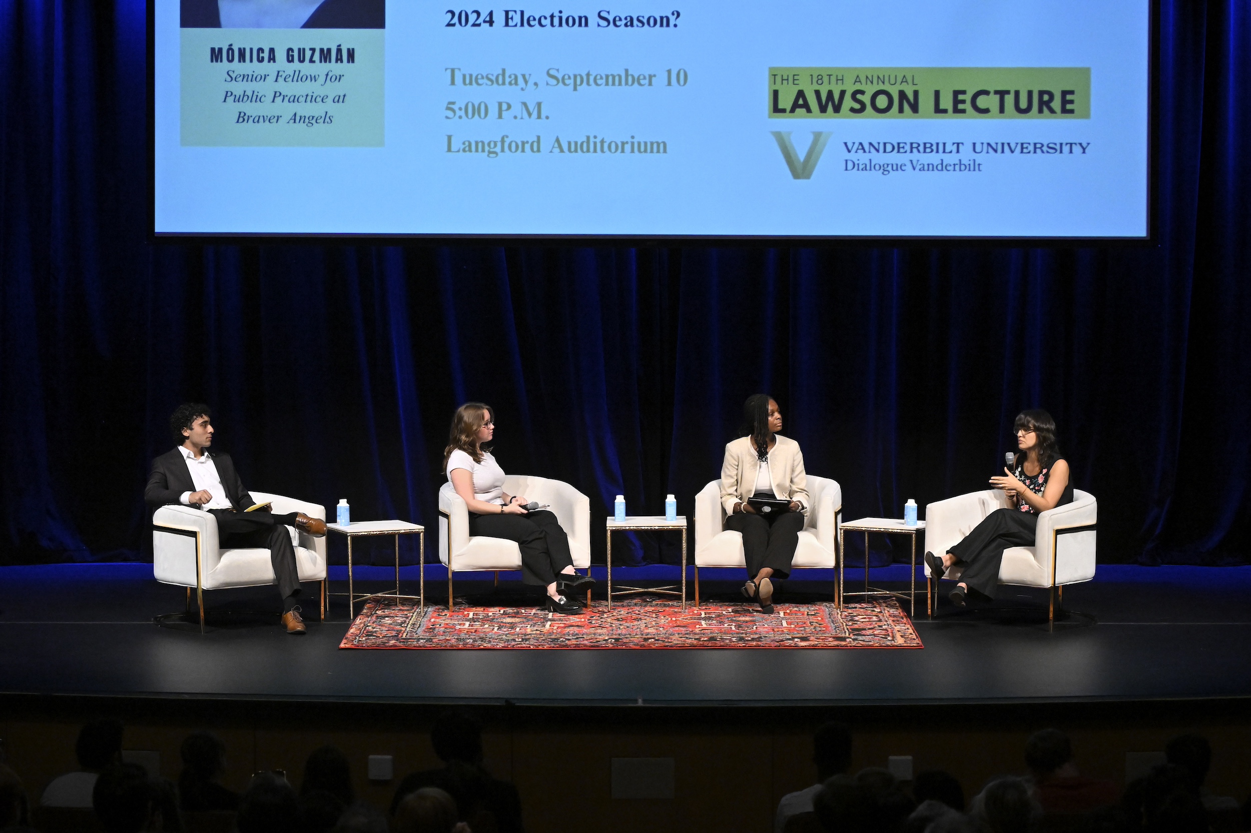 Students sitting on stage with Mónica Guzmán