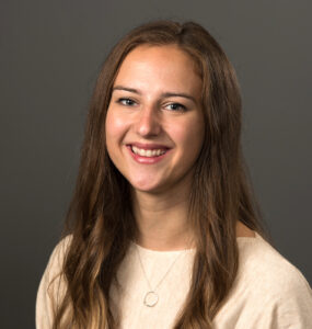 woman wearing cream-colored top with long brown hair