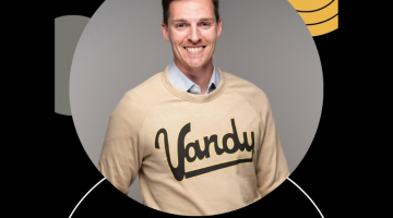 Pictured: Ryan Thomas in a Vandy sweatshirt smiling to represent his time with Vanderbilt Business.