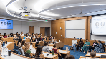 Pictured: a wide shot of the classroom. Every seat in the classroom is occupied. Panelists sit in a row facing the Vanderbilt Business attendees for the Women’s Leadership Summit.