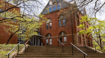 Pictured: An image of the exterior of Management Hall. This photo is taken from the bottom of the stairs near the school entrance closest to Vanderbilt's Law School. The photo was taken during autumn, and the trees that frame the building are sparse.