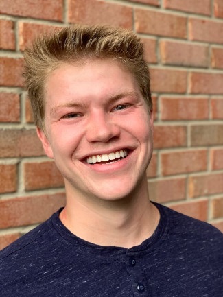 photograph of Will Henke in front of brick wall