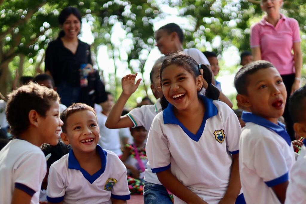 Schoolchildren in Colombia laugh during an outdoor break.