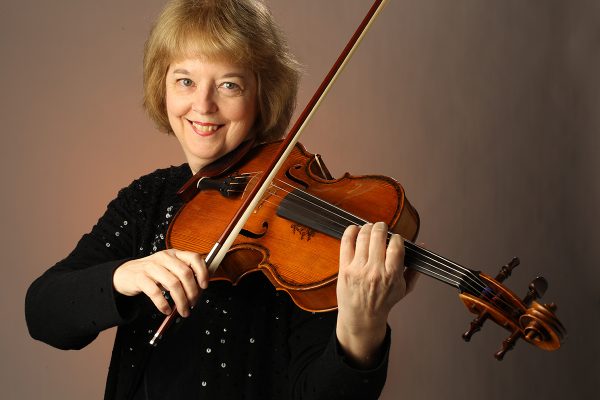 Kathryn Plummer posing with violin. 