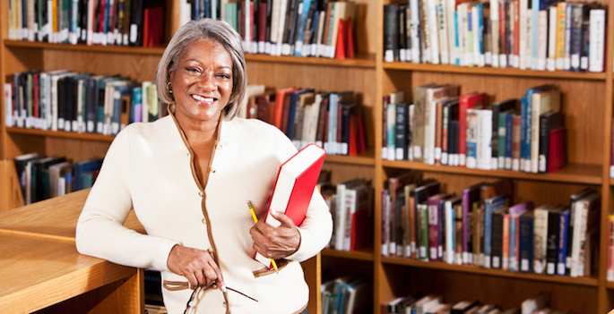 Mature African American woman in suit standing in school library