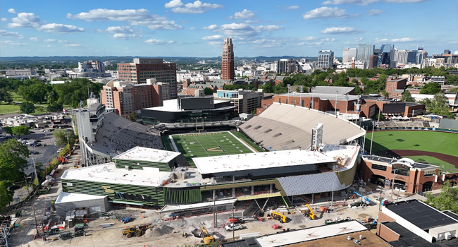 Aerial view of Vanderbilt University stadium under construction with downtown Nashville skyline in the background