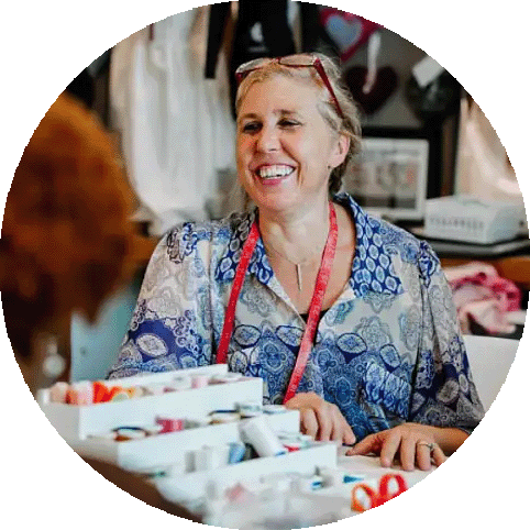 Smiling woman at the Sacred Stitches Project at The Wond'ry