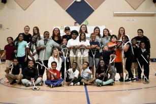 Emily Gaven and a group of students learning about lacrosse for the first time (Submitted photo)