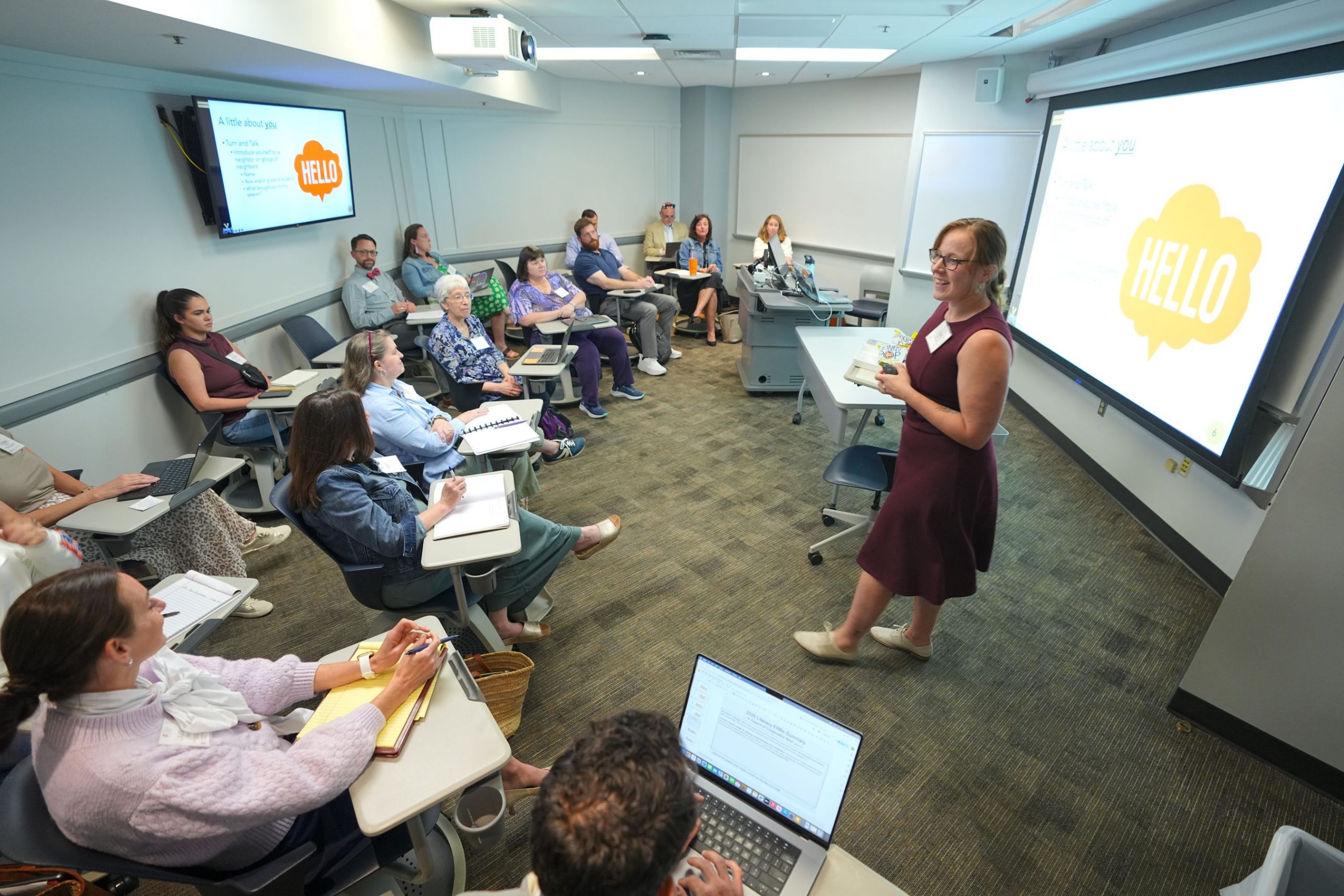 Samantha Gesel stands in front of a full classroom of conference attendees.