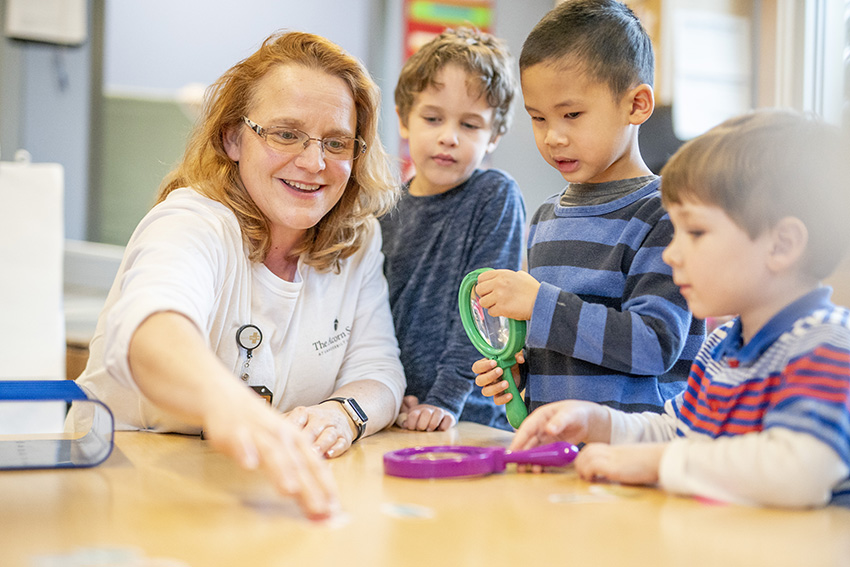 Marybeth Briney, an early childhood educator at The Acorn School, and her students. (John Russell/Vanderbilt)