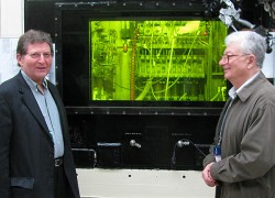 researchers standing outside an illuminated control room