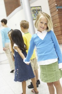 A line of young students going into school.