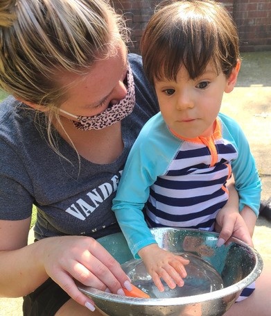 The Susan Gray School - adult and child with bowl of water