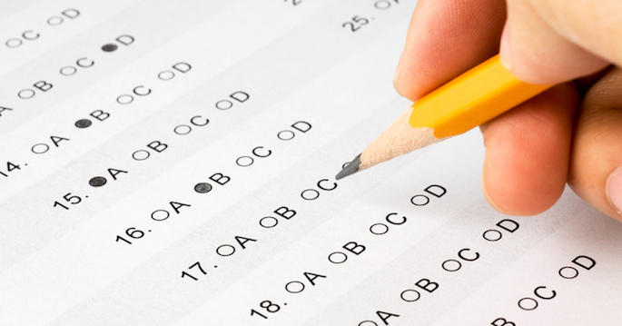 Hand completing a multiple choice exam. The answer form was created by me and is not copyrighted.