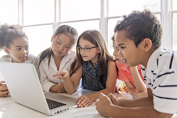 students gathered around a laptop