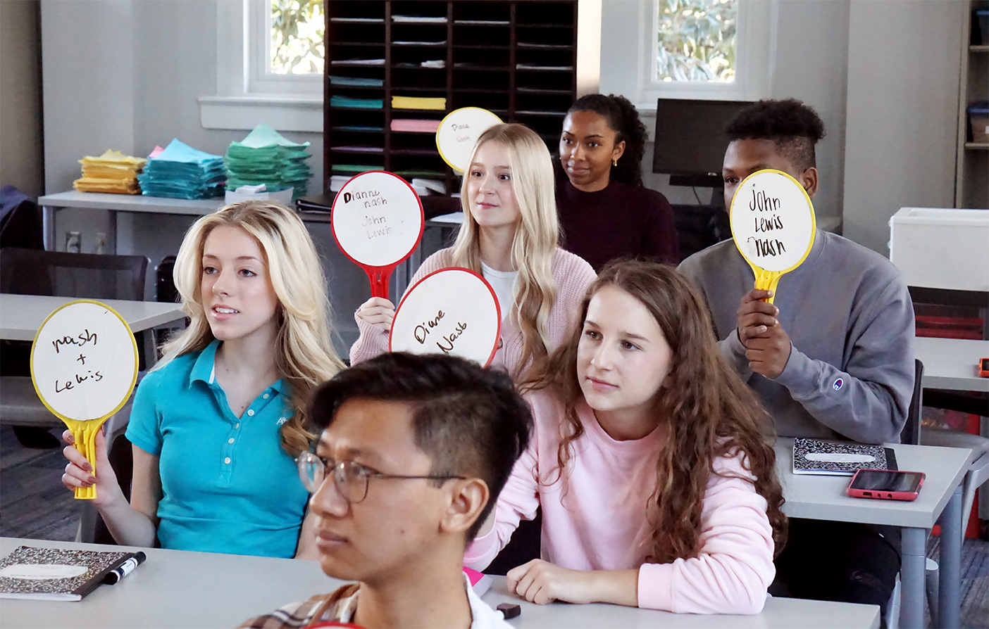 student holding up paddles in activity
