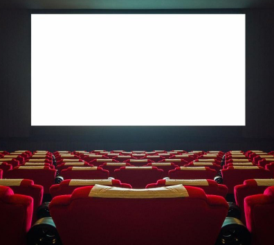 Empty movie theater with red seats facing a large, blank white screen, dim lighting