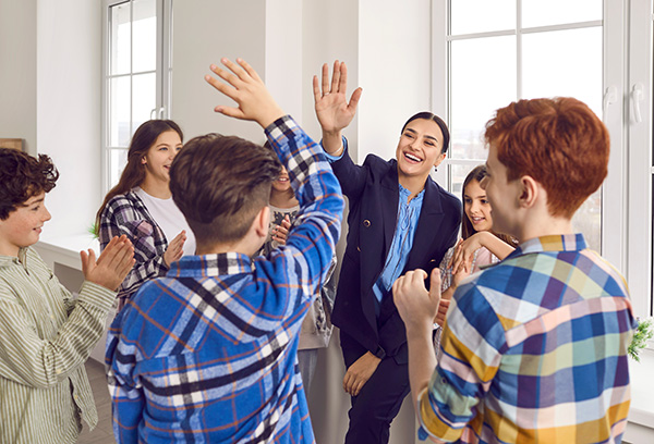 Teacher high-fiving group of students