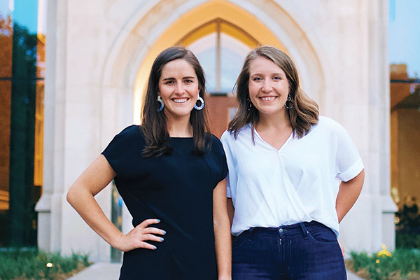 Two female VUSN students stand in front of main entrance